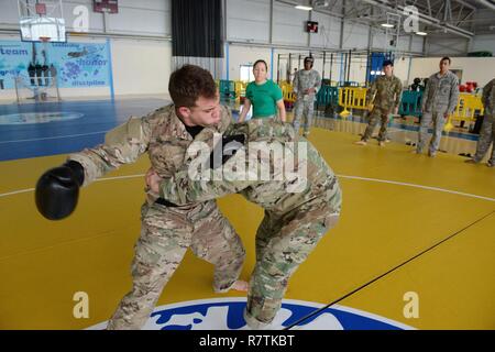 U.S. Army Sgt. Bryan Sandino, assistant instructor, with Allied Forces Northern Europe (AFNORTH) Battalion, punches one of the students who tries to clinch him, for a combatives level one class taught on Chièvres Air Base, Belgium, March 22, 2017. Stock Photo