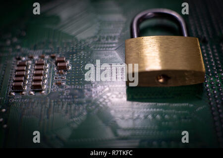 Metal lock sitting on electric circuit as concept of internet data security. Close-up full frame viewed from above with copy space Stock Photo