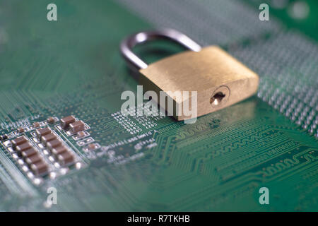 Brass lock sitting on electric circuit as concept of internet data security. Close-up full frame viewed from above with copy space Stock Photo