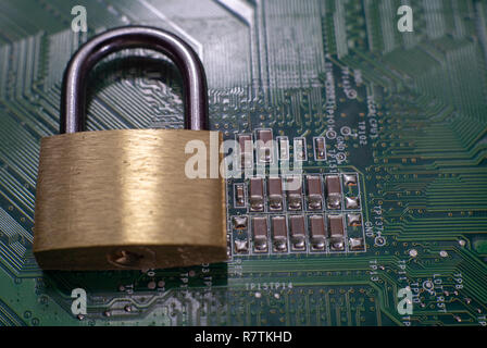 Brass lock sitting on electric circuit as concept of internet data security. Close-up full frame viewed from above with copy space Stock Photo