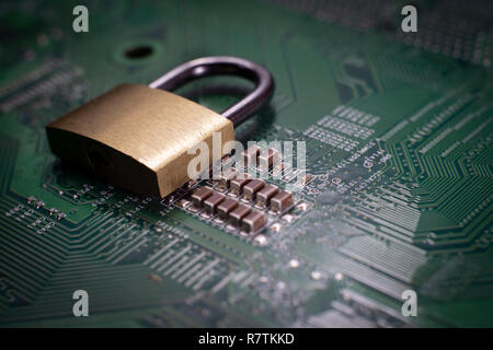 Brass lock sitting on electric circuit as concept of internet data security. Close-up full frame viewed from above with copy space Stock Photo
