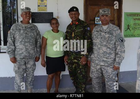 Chief Warrant Officer 3 Herminio Romero (from left to right), a project supervisor with the 448th Engineer Battalion, Shelma Talbert, a custodian at Belize Rural High School, Brig. Gen. David Jones, commander of the Belize Defence Force, and Staff Sgt. Juan Cruz, a project supervisor  also with the 448th, pose in front of a plaque April 8, 2017, honoring the soldiers of the 448th that built the high school in Double Head Cabbage, Belize. Romero and Cruz along with other Soldiers from the 448th helped to build the Belize Rural High School in Double Head Cabbage that sits next to the current BTH Stock Photo