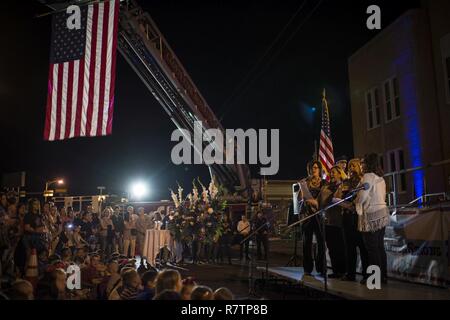 Community members from the towns surrounding the 27th Special Operations Wing gather to show their support for the 318th Special Operations Squadron March 20, 2017 in Clovis, N.M. The vigil comes a week after the 318th tragically lost three Air Commandos in a fatal crash. Stock Photo