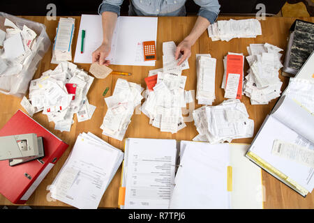 Woman sorting documents, records, invoices and receipts on a desk, for the tax return Stock Photo