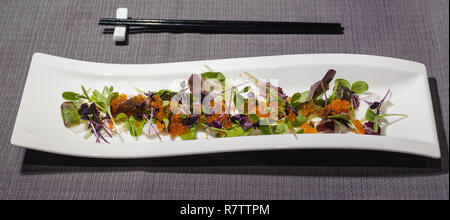 octopus carpaccio with small leaves salad and different types of caviar, fresh and raw food Stock Photo