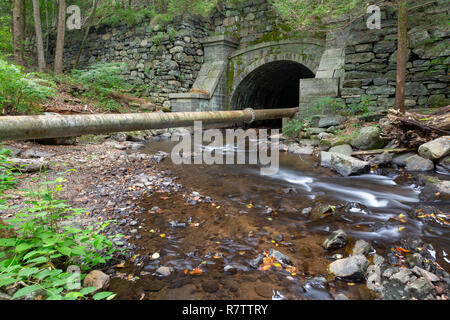 The Pocantico River flowing toward an old tunnel built from stone and bricks. Rockefeller State Park Preserve, New York Stock Photo