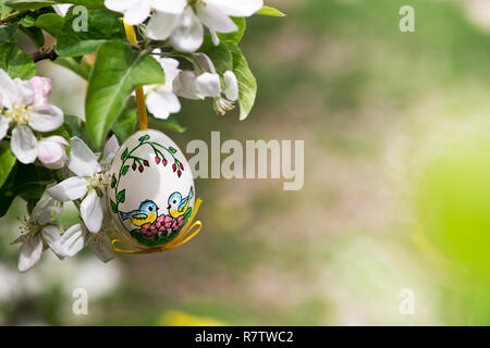 Easter egss hanging on the twig of apple tree in the garden Stock Photo