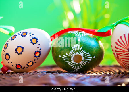 Painted easter eggs in the wicker basket in the grass. Stock Photo