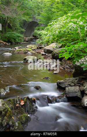 The Pocantico River flowing from below an old carriage road bridge. Rockefeller State Park Preserve, New York Stock Photo
