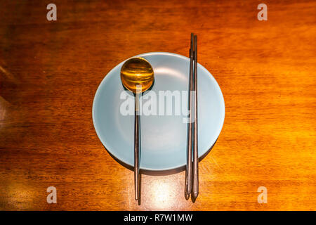 Empty Plate with Cutlery Spoon and Korean Iron Chopsticks Stock Photo