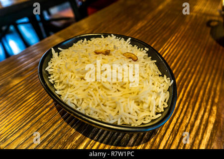 Indian Rice in a Black Bowl with Peanuts Served on a Table Stock Photo