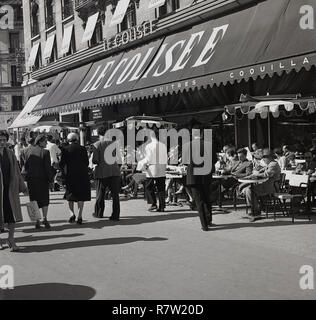 1950s, historical, people sitting in the open-air on the pavement outside the Restaurant Le Colisee, by the famous Ave de Champs-Elysees, Paris, France, Stock Photo