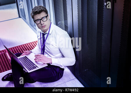 Serious handsome man sitting on the floor Stock Photo