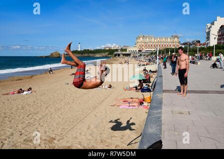 France, Pyrenees Atlantiques, Basque Country, Biarritz, acrobatics on the Grande Plage (town's largest beach) and the Hotel du Palais in the background Stock Photo