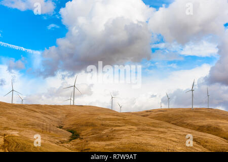 Wind turbines stand in stark contrast to the dark clouds along the rolling hills near Goldendale, Washington, in the Columbia River Gorge.