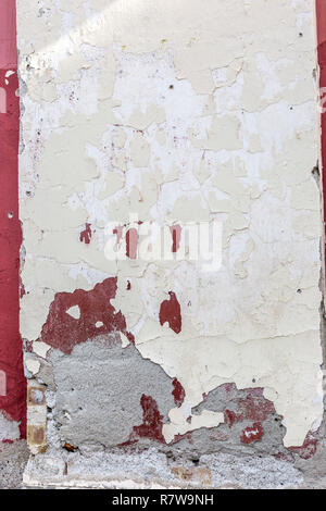 Old abandoned building facade wall with peeling paint, abstract background. Rough cracked stucco surface texture. Vertical photo Stock Photo