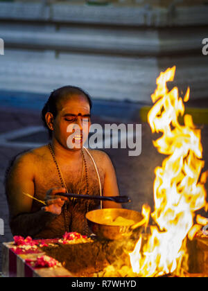 Singapore, Singapore. 11th Dec, 2018. A Hindu priest leads a prayer at the Sri Sivan Temple in the Geylang neighborhood. The temple was originally built in 1850s in the area that in now Orchard Road. The Geylang area of Singapore, between the Central Business District and Changi Airport, was originally coconut plantations and Malay villages. During Singapore's boom the coconut plantations and other farms were pushed out and now the area is a working class community of Malay, Indian and Chinese people. In the 2000s, developers started gentrifying Geylang and new housing estate developments Stock Photo