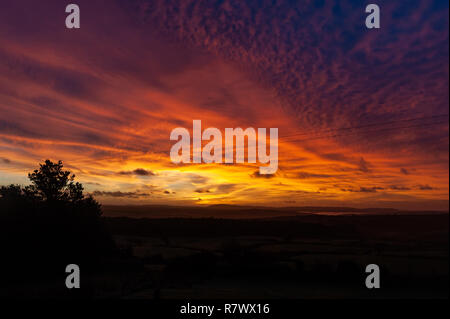 Ballydehob, West Cork, Ireland. 12th Dec, 2018. The sun rises dramatically over Ballydehob as a prelude to a day of sunshine and showers with top temperatures of 8 to 10° C. Credit: Andy Gibson/Alamy Live News. Stock Photo
