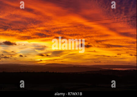 Ballydehob, West Cork, Ireland. 12th Dec, 2018. The sun rises dramatically over Ballydehob as a prelude to a day of sunshine and showers with top temperatures of 8 to 10° C. Credit: Andy Gibson/Alamy Live News. Stock Photo