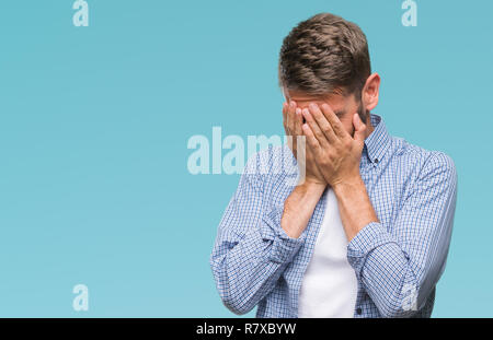 Young handsome man wearing white t-shirt over isolated background with sad expression covering face with hands while crying. Depression concept. Stock Photo