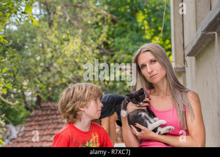 Mother and child, mom is holding a cat Stock Photo