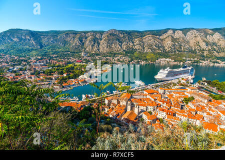 A massive cruise ship docks in the bay of Kotor in the ancient coastal city on the Adriatic Sea, Kotor, Montenegro. Stock Photo