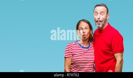 Middle age hispanic couple in love over isolated background making fish face with lips, crazy and comical gesture. Funny expression. Stock Photo