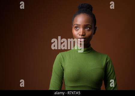 Young beautiful African Zulu businesswoman thinking and looking up Stock Photo