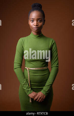 Young beautiful African Zulu businesswoman against brown backgro Stock Photo