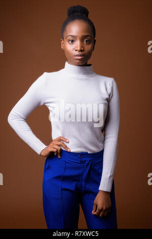 Young beautiful African Zulu businesswoman against brown backgro Stock Photo