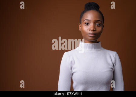 Young beautiful African Zulu businesswoman against brown backgro Stock Photo