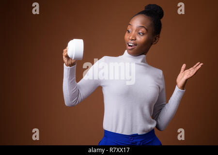 Young beautiful African Zulu woman holding coffee cup Stock Photo