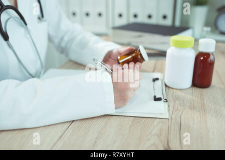 Doctor writing prescription for generic drugs in medical office Stock Photo