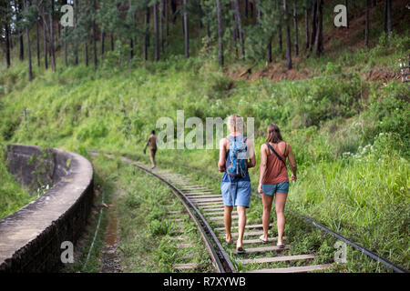 Ella, Sri Lanka - August 5, 2018: Two tourists walking on train tracks Stock Photo