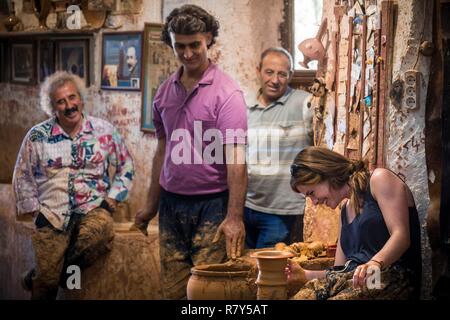 Turkey, Central Anatolia, Nevşehir province, Cappadocia UNESCO World Heritage Site, Avanos, the potter Galip KÖRÜKÇÜ teaches a young woman to model her pottery on a walking tour in his workshop Stock Photo