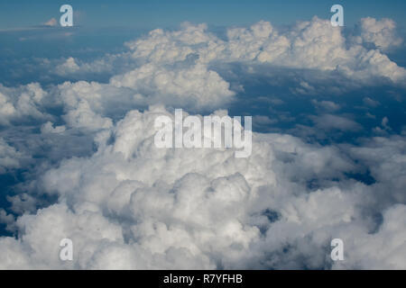 Above the clouds from airplane - blue skies puffy clouds - billowing cumulus clouds - cotton ball cumulous clouds Caribbean ocean - cumulus congestus Stock Photo