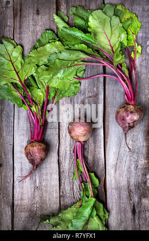 Raw beetroot with green leaves on wooden background Stock Photo