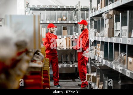 Warehouse workers in red uniform during the work in the storage Stock Photo