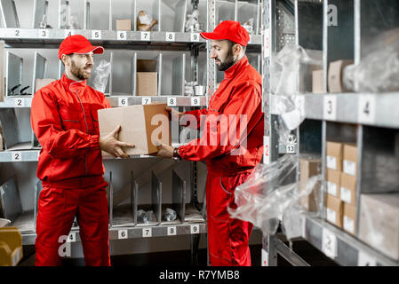 Warehouse workers in red uniform during the work in the storage Stock Photo