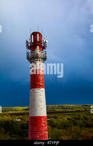 Red and white old pipe on a background of blue sky. Stock Photo