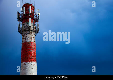 Red and white old pipe on a background of blue sky. Stock Photo