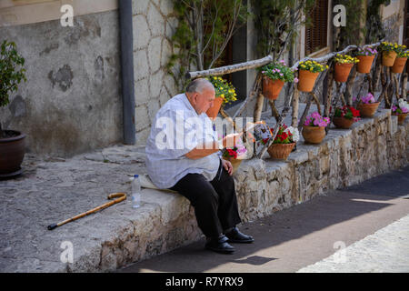 Valldemossa, Mallorca, Balearic Islands, Spain - July 21, 2013: A local man sitting reading a newspaper. Stock Photo