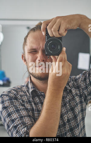 Photographer looking through camera at viewer. Stock Photo