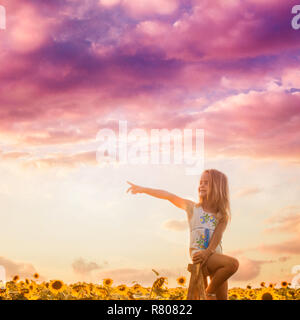 The girl looks around the sunflower field Stock Photo