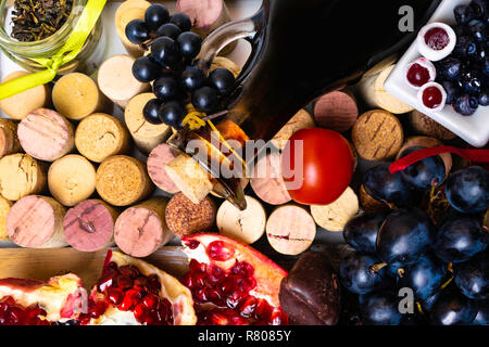 balsamic vinegar in a glass jug with fresh red grapes on wine corks background, rich with resveratrol, flavonoids, antioxidants, pomegranate, cranberr Stock Photo