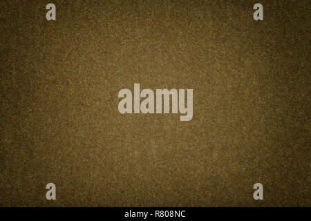 Dark brown matte background of suede fabric, closeup. Velvet texture of seamless olive woolen felt with vignette. Stock Photo