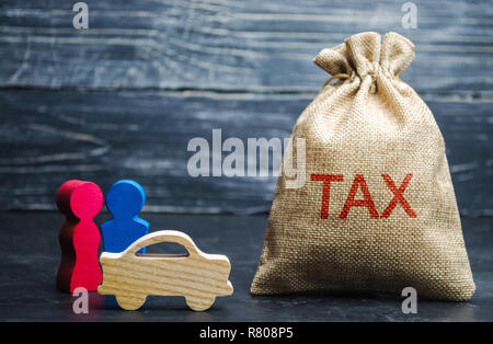 A bag with money and the word Tax and a car with family. Concept the taxes payment for auto. Vehicle, road, disc tax. Is an annual tax that is levied  Stock Photo