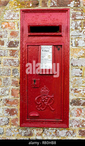 Harbridge, England - October 22, 2018: Old red mail box in England in a brick wall with lots of lichen. Stock Photo