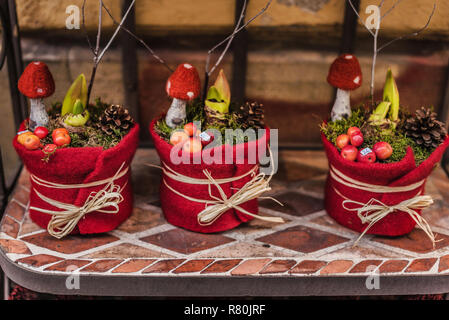Vienna, Austria - December 30, 2017. Christmas decorative pots with florist handmade craft composition. Pine cones, felt fly agaric mushrooms, berries Stock Photo