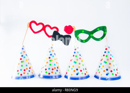 Carnival caps and funny masks on a white background isolated. Party tools and decoration. Happy birthday layout. Purim. Design concept. Select focus,  Stock Photo